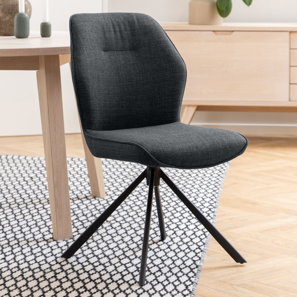 Sedia Ann grigio scuro in un ambiente moderno con pavimento in legno chiaro e decorazioni minimaliste.