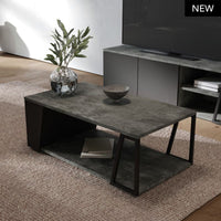 Tavolino Albi in ambiente moderno, con finitura cemento e struttura nera. Ideale per un soggiorno elegante e funzionale con spazio per riporre oggetti.
