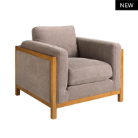 Poltrona Daniel con seduta tessuto marrone e struttura in legno chiaro. Perfetta per arredare salotti moderni con comfort e stile.