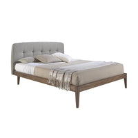 Letto Luxor moderno con testiera capitonné in tessuto grigio e struttura in legno noce, vista angolare.