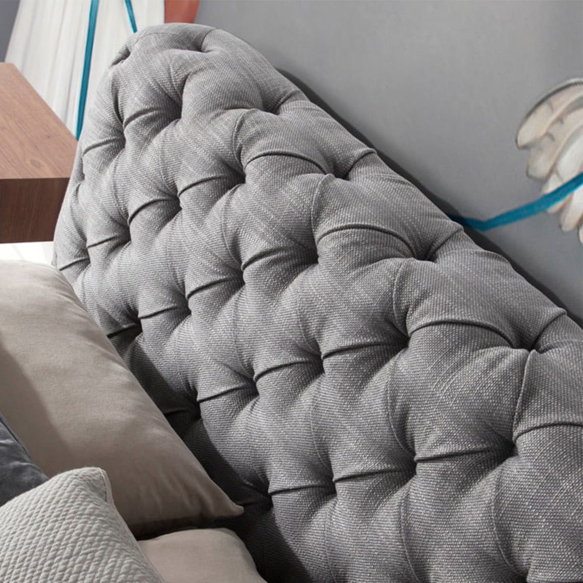 Dettaglio della testiera capitonné del Letto Marene in tessuto grigio, con design elegante e confortevole.