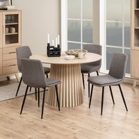 Set di quattro Sedie Bella grigie attorno a un tavolo rotondo in legno chiaro, ideale per sale da pranzo contemporanee.