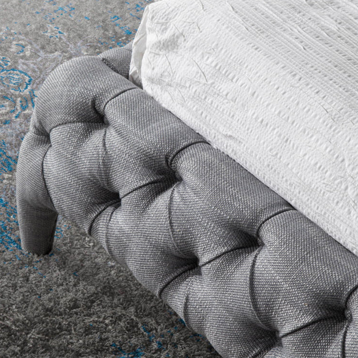 Dettaglio del rivestimento capitonné del Letto Marene in tessuto grigio, con struttura robusta e design raffinato.