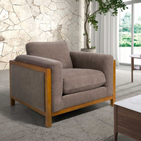 Poltrona Daniel con seduta tessuto marrone e struttura in legno chiaro. Perfetta per arredare salotti moderni con comfort e stile.