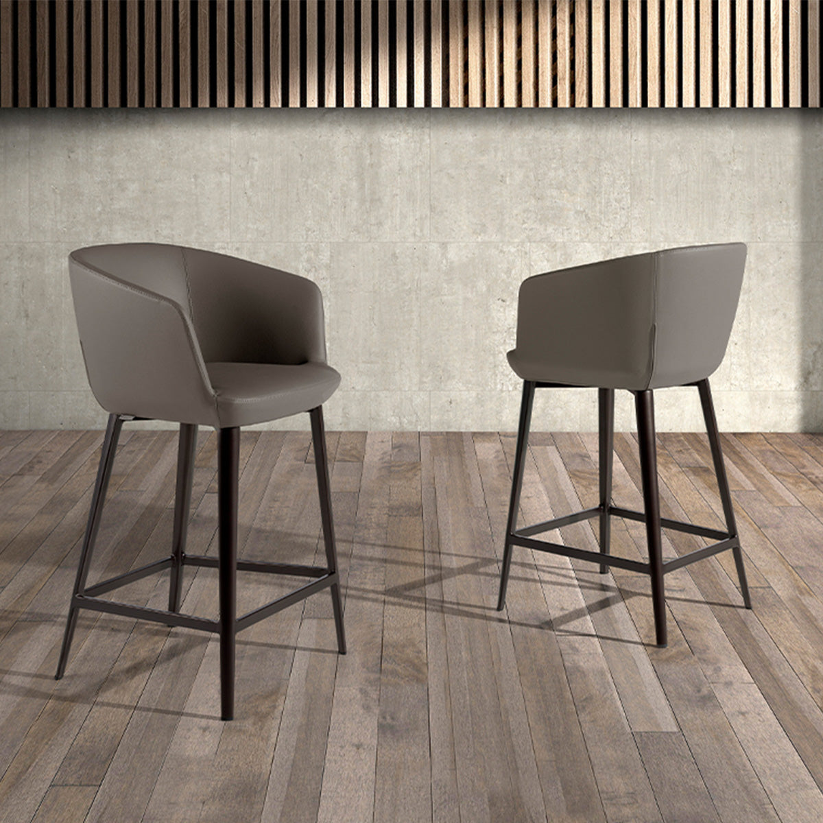 Scopri lo sgabello Gaia, con seduta ecopelle grigia e gambe inox marrone. Unisce comfort e design moderno per cucina e sala. Misure: 56x53x91 cm.