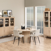 Set di quattro Sedie Bella beige attorno a un tavolo rotondo in legno chiaro, perfetto per ambienti moderni e accoglienti.