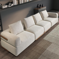 Divano Gustav moderno a 4 posti in tessuto beige sfoderabile, con gambe in PVC, ideale per salotti eleganti. Dimensioni 396x105x90cm.