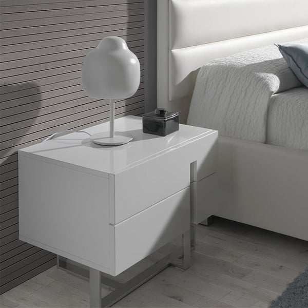 Scopri Comodino Nara: moderno, in DM laccato bianco lucido con gambe in acciaio inox. Perfetto in camera da letto. Misure: 60x42x45 cm, montato.