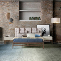 Letto Lusiana in una camera elegante con arredi moderni, struttura in legno noce e testiera capitonné grigia con poggiatesta in similpelle.