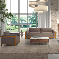 Poltrona Daniel con seduta tessuto marrone e struttura in legno chiaro. Perfetta per arredare salotti moderni con comfort e stile.
