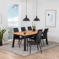 Sala da pranzo moderna con sedie Arosa nere e struttura in metallo nero opaco, abbinate a un tavolo in legno naturale.