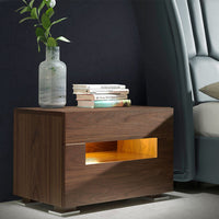 Comodino Nancy in legno impiallacciato noce con led, due cassetti e sistema chiusura rallentata. Misure 58x38x41 cm. Design moderno ideale per ogni camera.