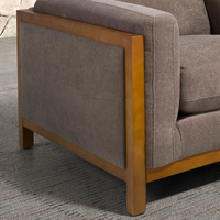Poltrona Daniel con seduta tessuto marrone e struttura in legno chiaro. Perfetta per arredare salotti moderni con comfort e stile.