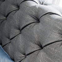 Primo piano del tessuto grigio capitonné del Letto Marene, che evidenzia la qualità e la cura nei dettagli.