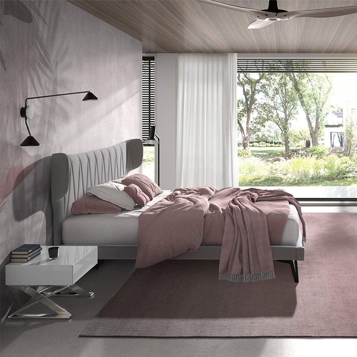 Letto Mandela in una camera luminosa con vista sul giardino, copriletto rosa e testata imbottita grigia, stile elegante e accogliente.