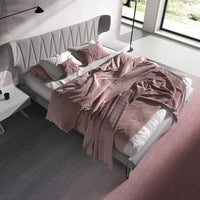 Vista dall'alto del Letto Mandela con copriletto rosa e cuscini coordinati, in una camera moderna con dettagli di design raffinati.