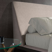 Dettaglio della testata del Letto Mara in tessuto grigio chiaro, design inclinato con cuscini coordinati, stile elegante.