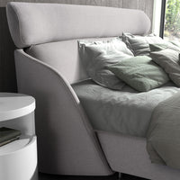 Dettaglio della testata del Letto Malung con design imbottito e struttura in tessuto grigio chiaro, perfetto per un comfort elegante.